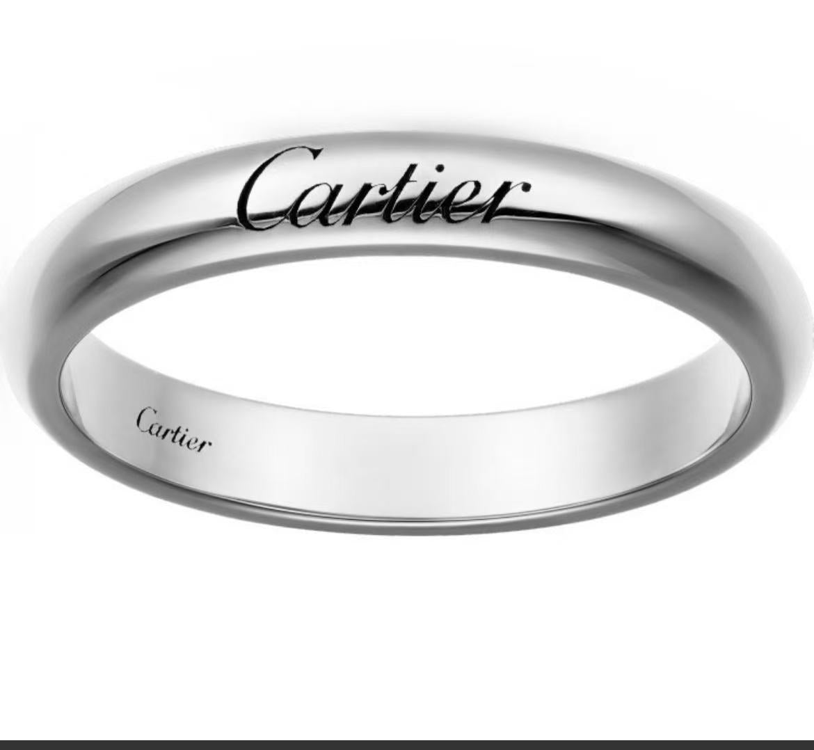 A polished silver-tone Cartier ring with the brand name engraved on the outer band and 'Cartier' stamped inside, shown against a plain white background.