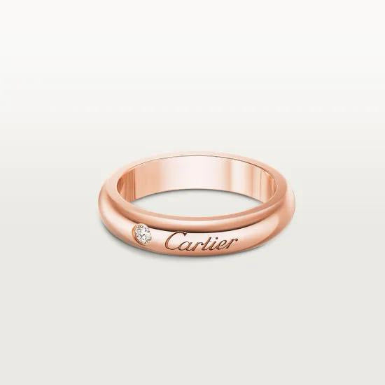 Rose gold Cartier ring with a diamond on a light gray background