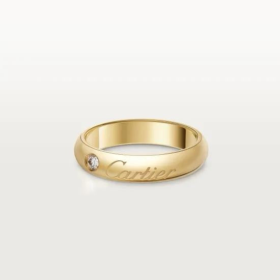 Gold Cartier ring with a diamond on a white background