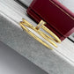 Gold bracelet with a red box on a textured surface