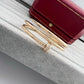 Gold bracelet and ring on a textured surface with a red jewelry box in the background