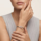 Large Cartier Juste un Clou white gold bracelet with diamond accents, designed by Zerra Jewelry, showcased on a display stand.
