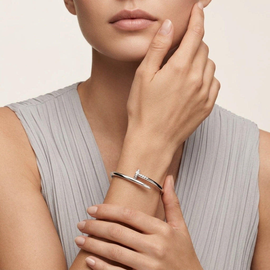 Large Cartier Juste un Clou white gold bracelet with diamond accents, designed by Zerra Jewelry, showcased on a display stand.