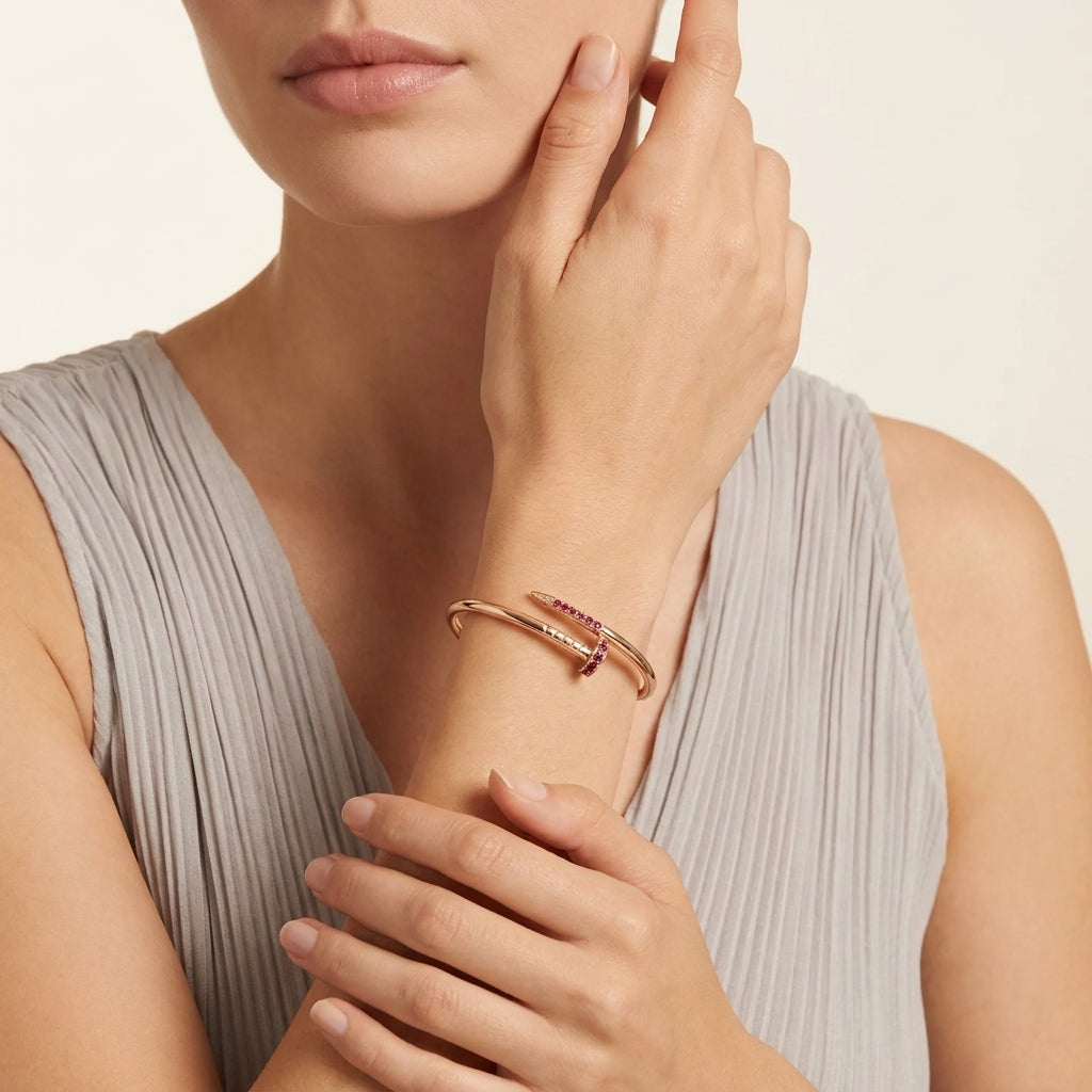 Woman wearing a rose gold bracelet with gemstones on a neutral background
