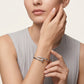Woman wearing a silver bracelet on a neutral background
