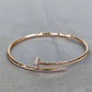 Gold bracelet with a small diamond on a gray background