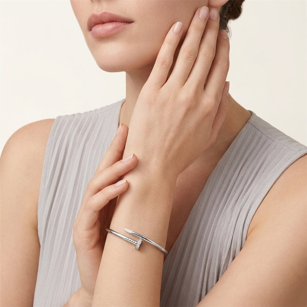 Woman wearing a silver bracelet on her wrist with a neutral background