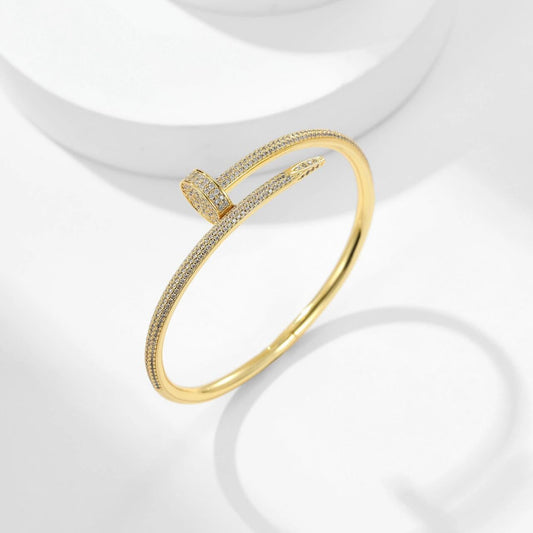 Gold bracelet with diamond accents on a white background