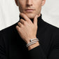 Man wearing a silver bracelet on a plain background