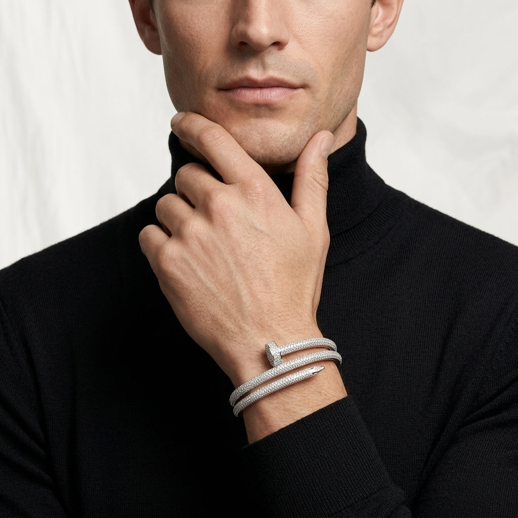Man wearing a silver bracelet on a plain background