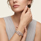 Woman wearing a silver bracelet on a neutral background