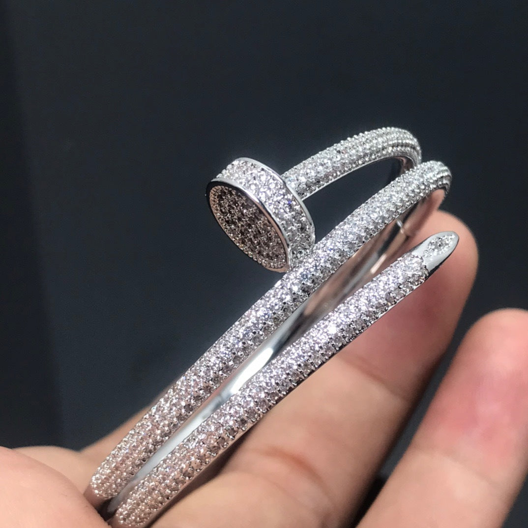 Two sparkling rings on a finger against a dark background