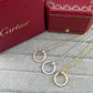 Three Cartier hoop necklaces with pavé-set round stones in gold, silver, and rose gold, displayed on a gray textured surface with red Cartier gift boxes in the background.