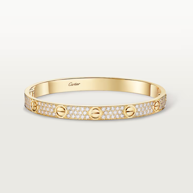 Gold bracelet with diamond accents on a light gray background