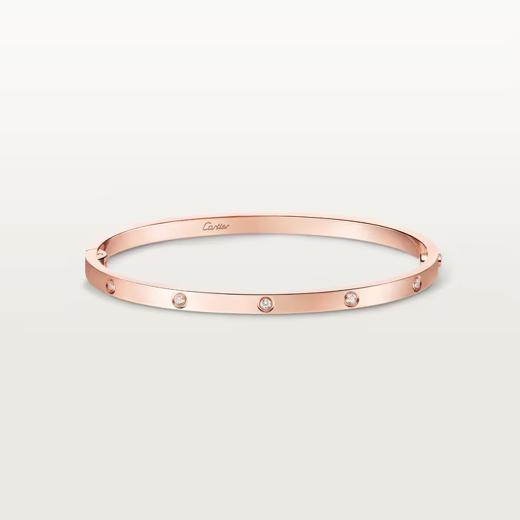 Rose gold bracelet with small diamonds on a light gray background