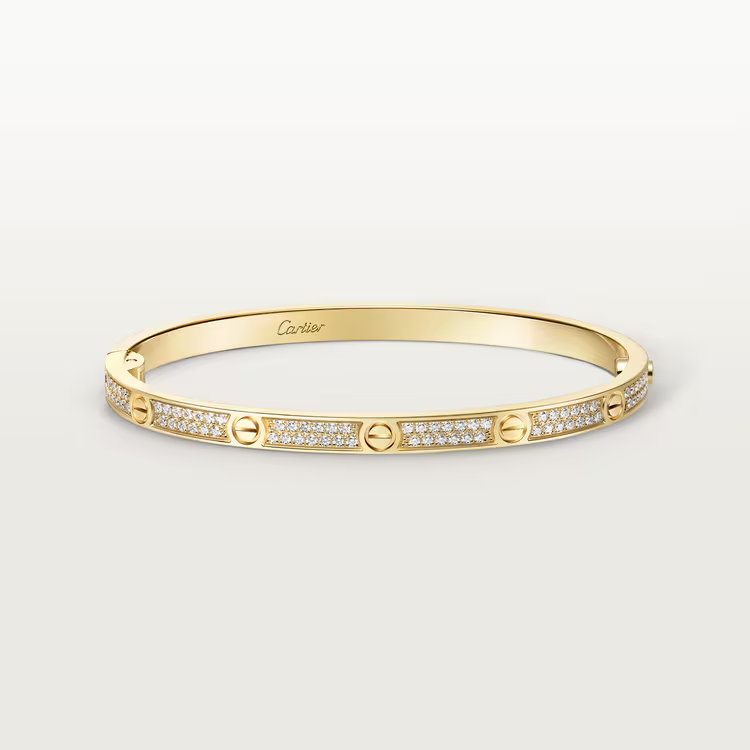 Gold bracelet with diamond accents on a light gray background