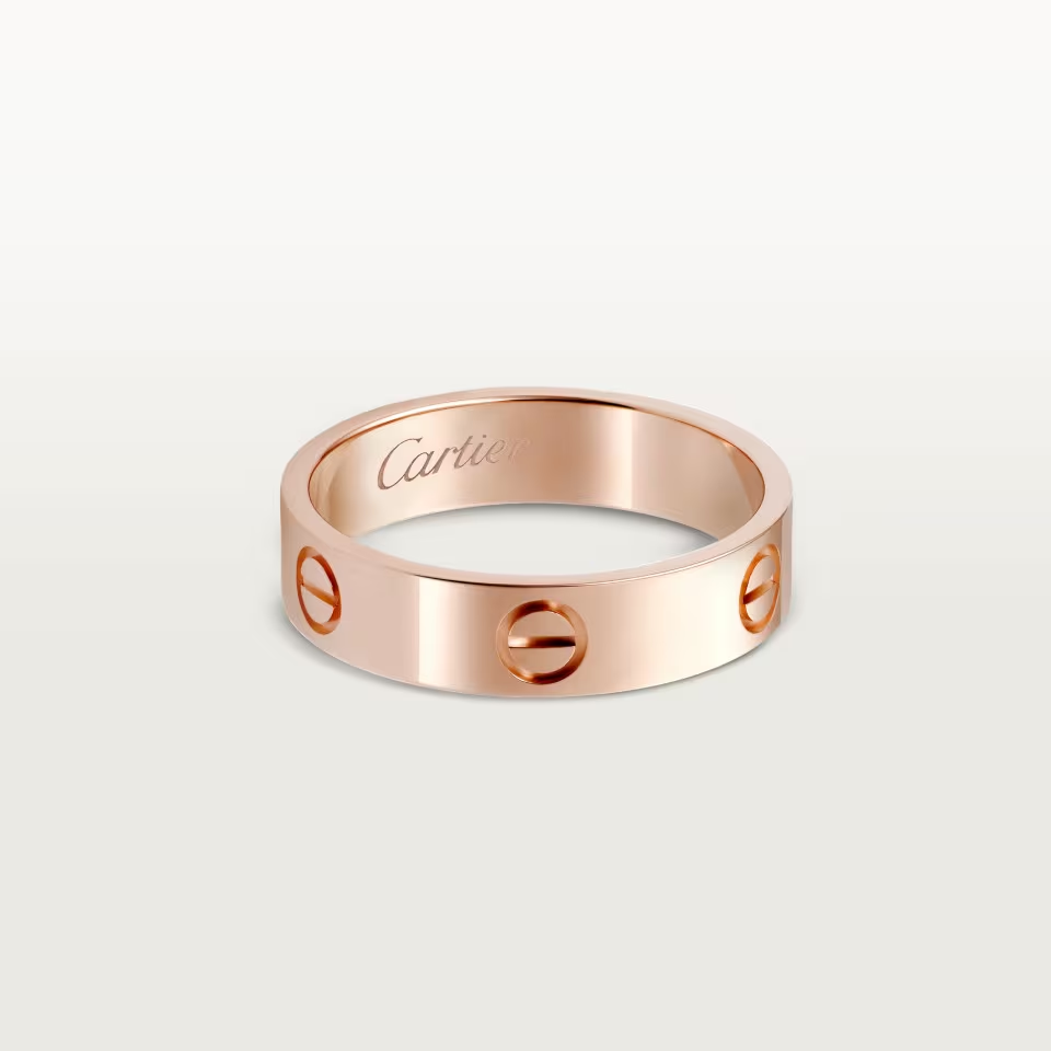 Rose gold Cartier ring on a light gray background