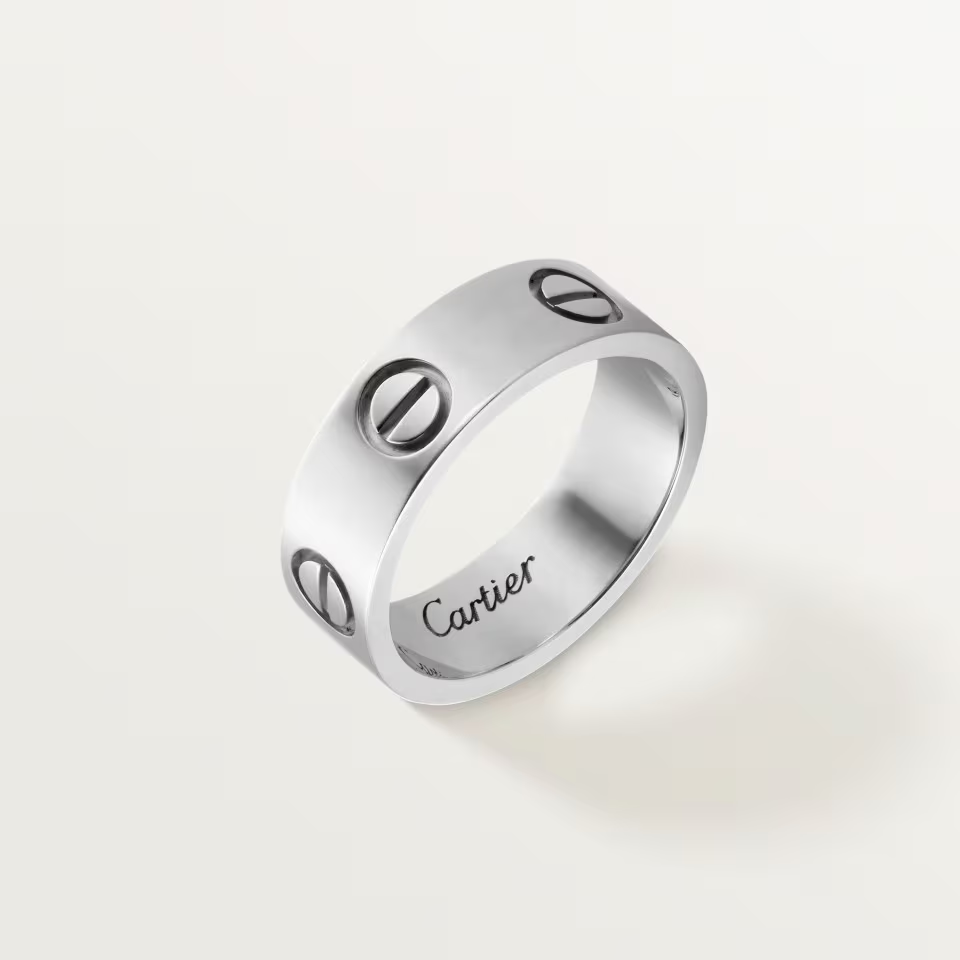 Silver Cartier ring with engraved design on a light gray background