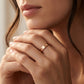 Close-up of a person wearing a rose gold ring with a subtle design.