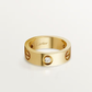 Gold Cartier ring with a diamond on a light gray background