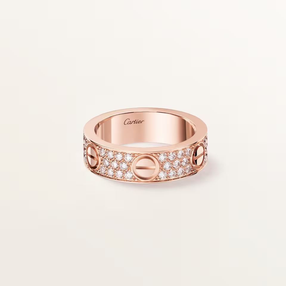 Rose gold ring with diamonds on a light beige background