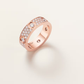 Rose gold ring with diamond accents on a light pink background