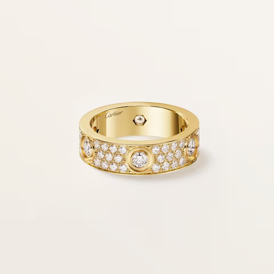 Gold ring with diamonds on a light beige background