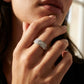 Close-up of a hand wearing a diamond ring with a blurred background