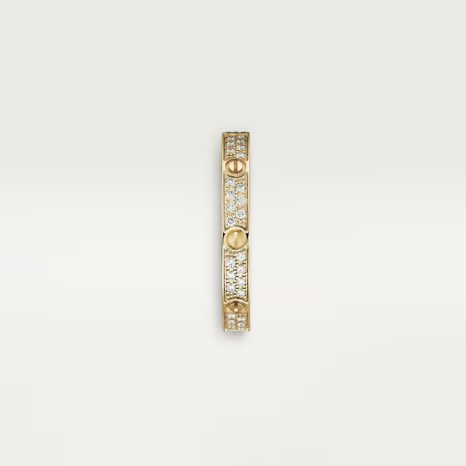 Gold bracelet with embedded diamonds on a light beige background