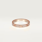 Rose gold Cartier ring with diamonds on a light beige background