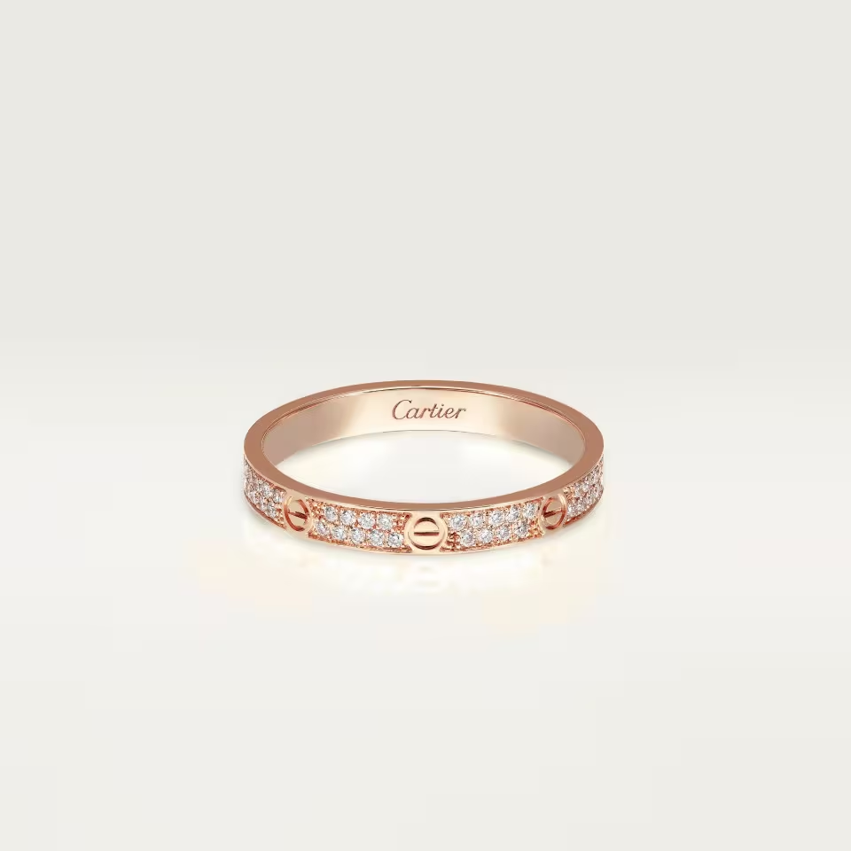 Rose gold Cartier ring with diamonds on a light beige background