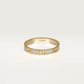Gold ring with diamond accents on a light beige background