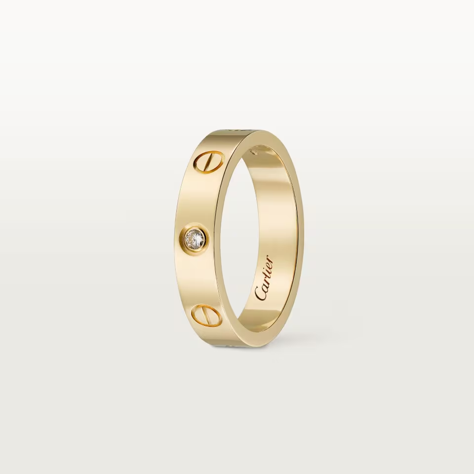 Gold ring with a diamond on a light gray background