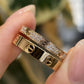 Close-up of a gold bracelet with diamond accents held by a hand.