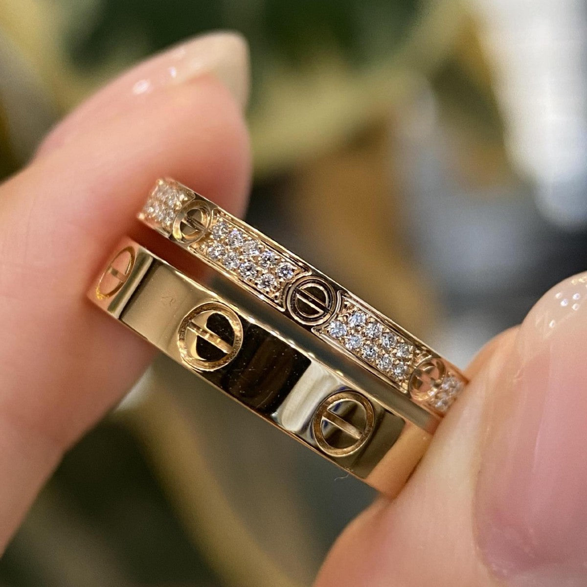 Close-up of a gold bracelet with diamond accents held by a hand.