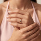 Close-up of a woman's hands with a rose gold ring on her left hand.