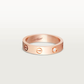 Rose gold Cartier ring with a diamond on a light gray background