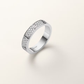 Silver ring with diamond accents on a light gray background