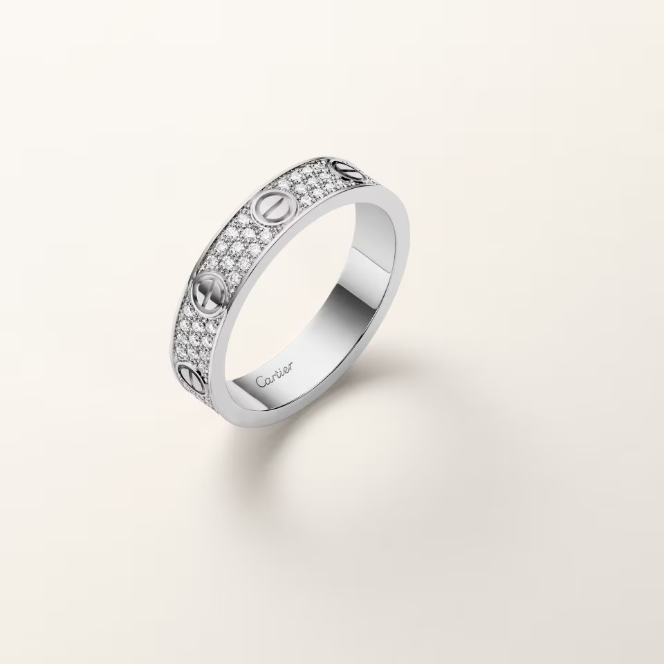 Silver ring with diamond accents on a light gray background