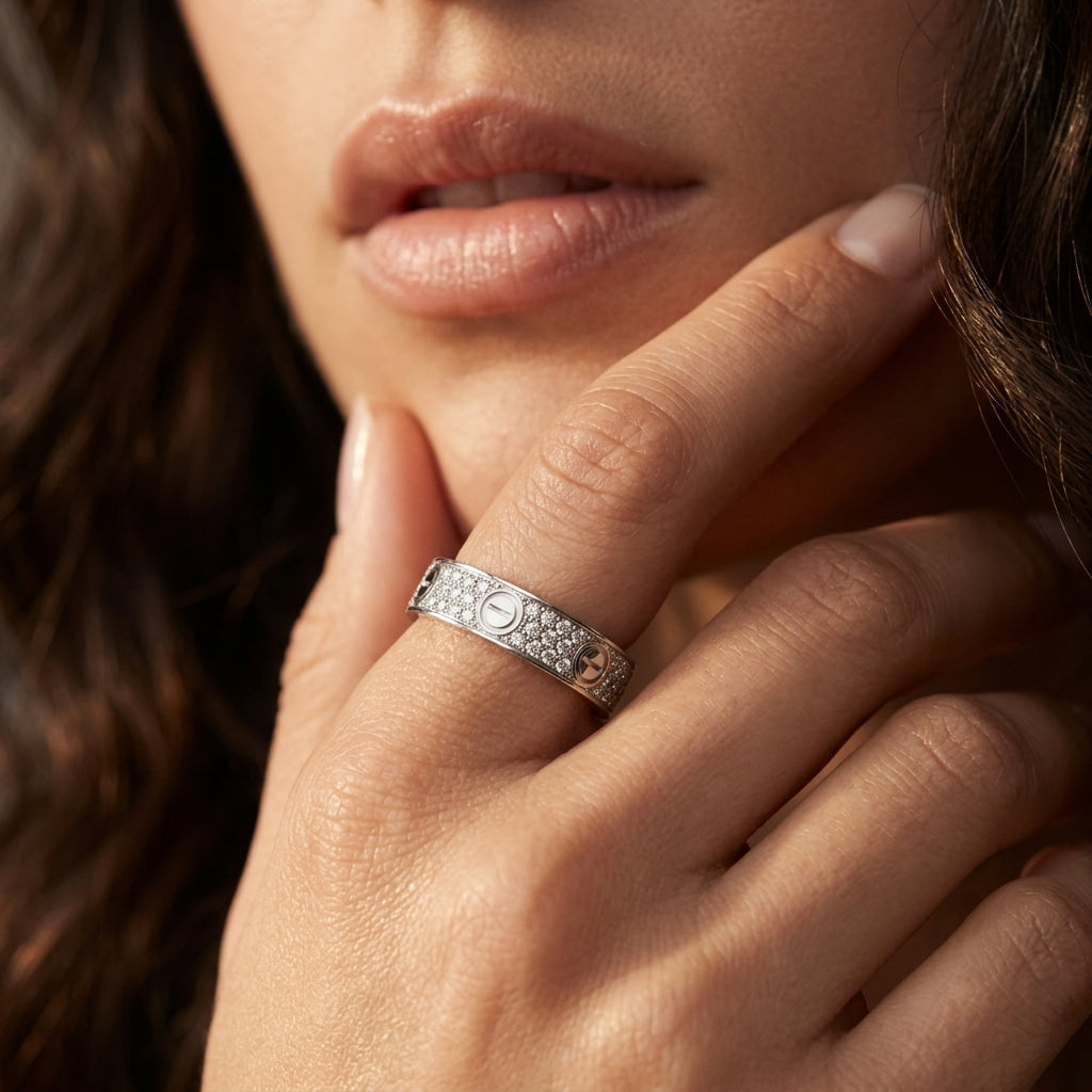 Close-up of a hand wearing a silver ring with intricate design, touching the chin.