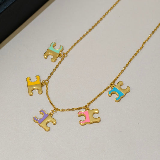 A gold-tone necklace with five dangling horse-shaped charms in pastel colors including mint green, yellow, blue, purple, and pink, displayed on a light neutral surface.