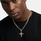 Man wearing a black shirt with a silver chain and cross pendant necklace.