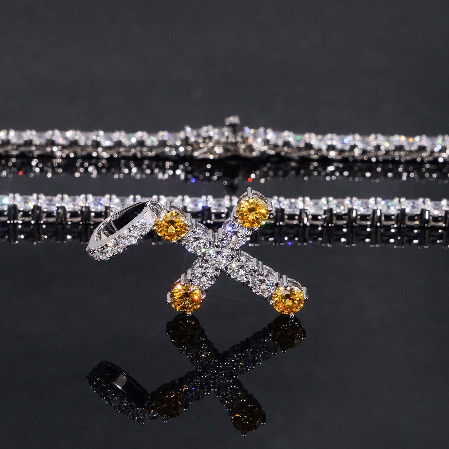 Jewelry with yellow and clear stones on a reflective surface