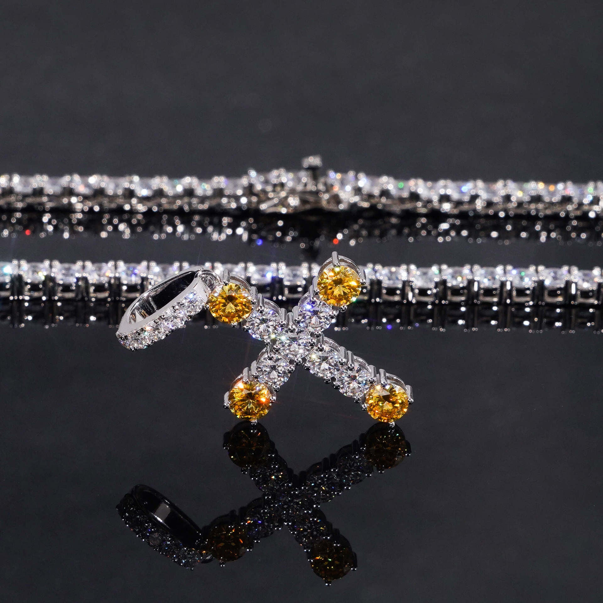 Jewelry with yellow and clear stones on a reflective surface