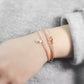 Close-up of a wrist wearing two bracelets on a gray surface