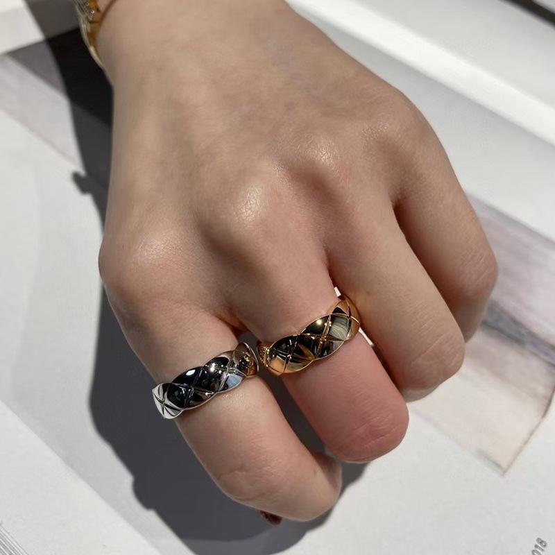 Hand wearing two Chanel_COCO_CRUSH_RING on a light background