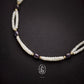 Pearl and purple bead necklace on a dark background