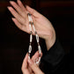Hand holding a beaded necklace against a dark background