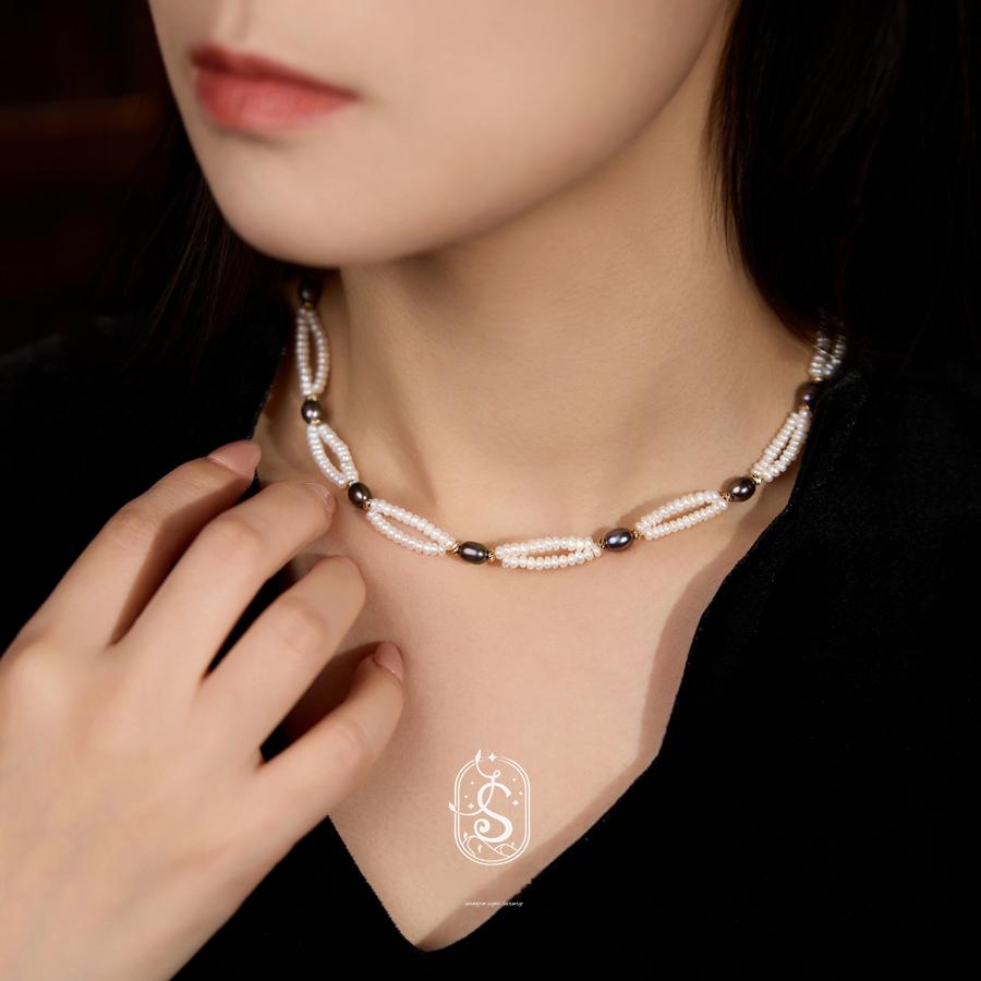 Pearl necklace worn by a model with a dark background