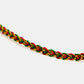 Bracelet with red, green, and gold braided pattern on a white background
